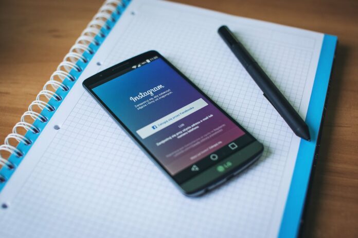 Téléphone avec l'application instagram, posé sur un cahier